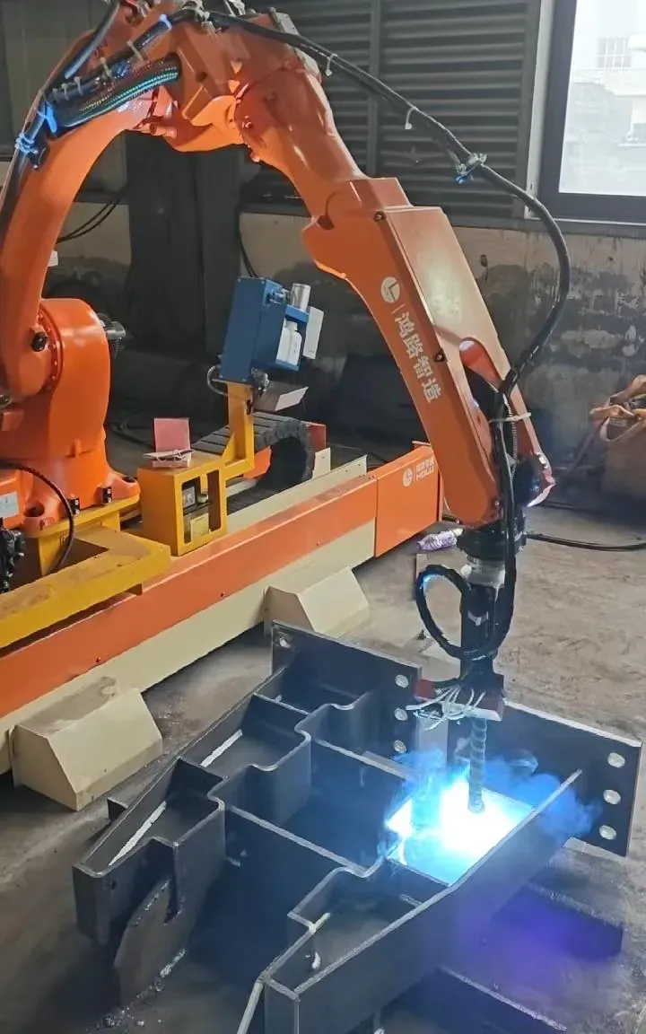 Robot welding a steel bracket assembly.